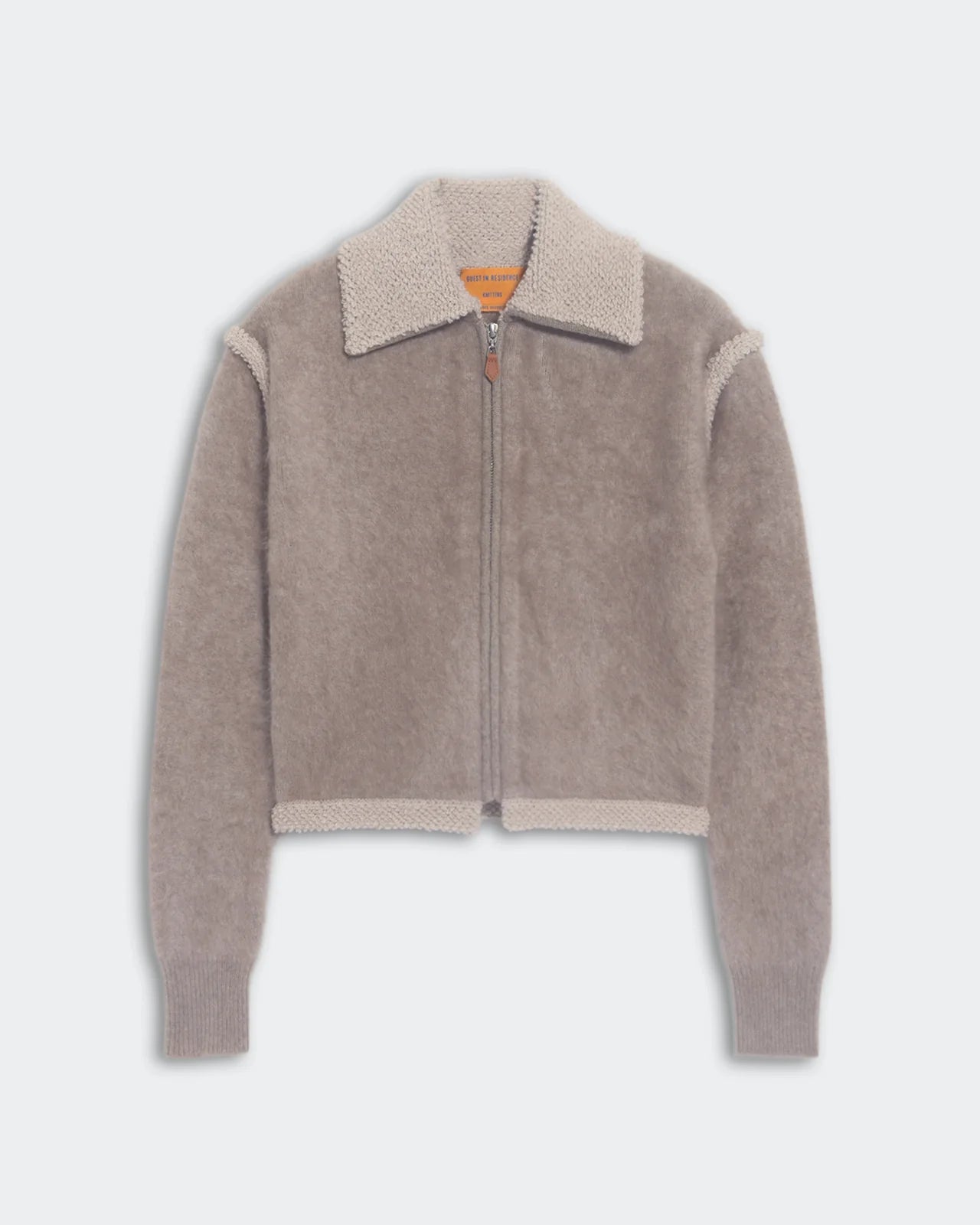 The Grizzly Frankie Jacket by Guest in Residence is a gray cropped cashmere piece with a wide collar, ribbed cuffs, soft fuzzy texture, and contrasting trim along the collar, hem, and seams.