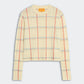The Shrunken Check Crew by Guest in Residence is a cream cashmere women’s sweater with a red and blue check jacquard pattern, crew neck, and ribbed cuffs and hem.