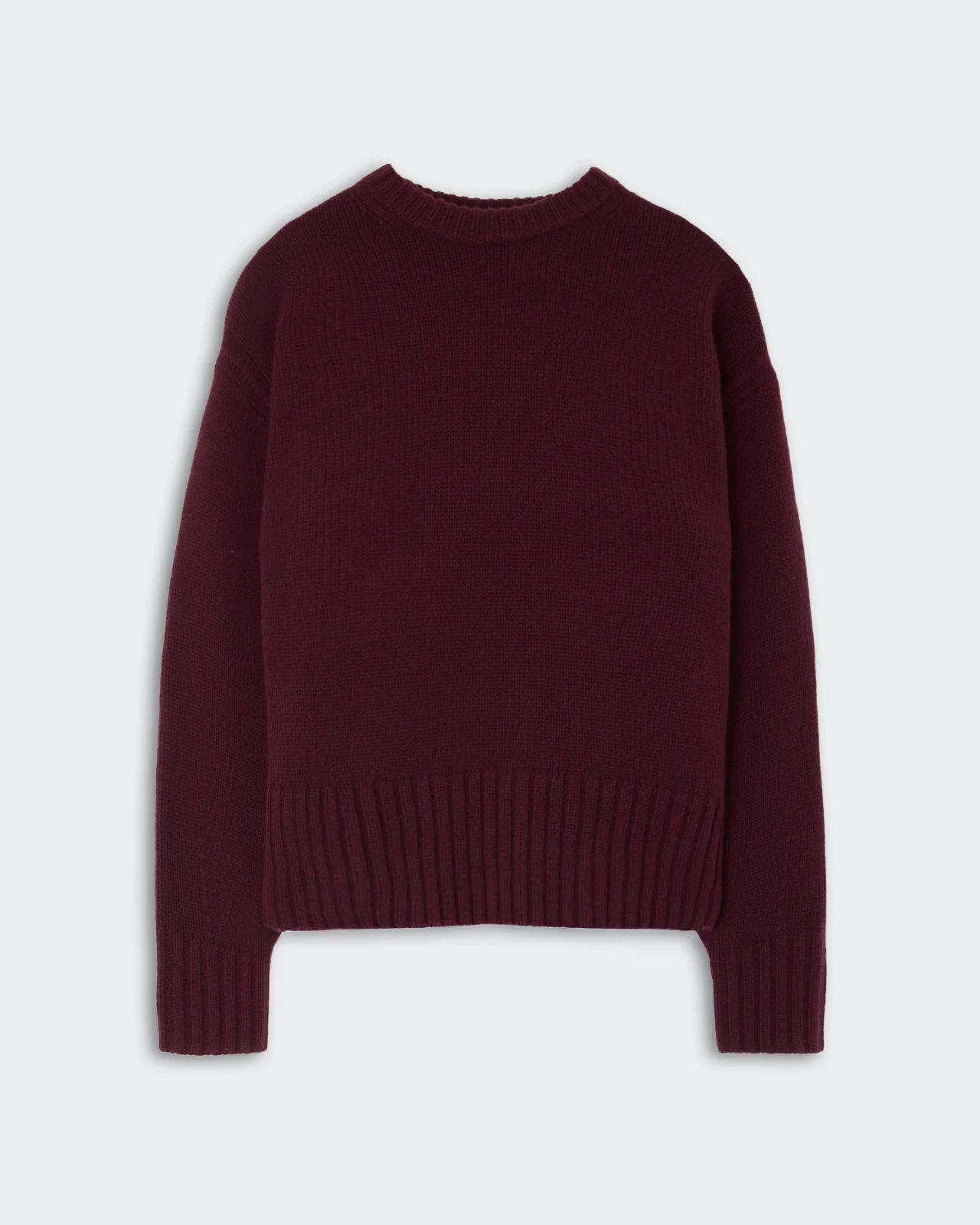 The Guest in Residence Cozy Crew Cashmere Sweater is a women’s long-sleeved, dark burgundy pullover featuring a classic crew neckline and ribbed cuffs and hem, shown laid flat on a light background.