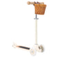 The Banwood Scooter by Banwood is a cream-colored toy with three wheels and a wicker basket attached to the handlebar, designed to enhance balance and fine motor skills.