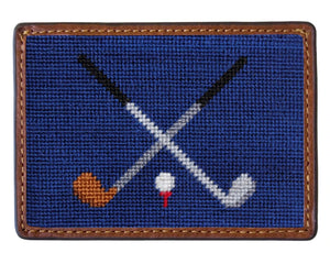 The Crossed Clubs Card Wallet by Smathers & Branson features a rectangular blue patch with two crossed golf clubs and a golf ball on a tee, bordered by brown stitching—ideal for a hand-stitched wallet or needlepoint card case.