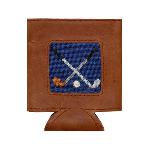 The Smathers & Branson Crossed Clubs Can Cooler pairs brown Italian leather with a stitched blue patch featuring two crossed hockey sticks and pucks, effortlessly blending classic style and the durable performance of premium neoprene.