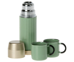 A mint Maileg Thermos and Cups set includes a thermos flask with a silver top, two mint mugs with black rims and handles, perfect for hiker mice, and also comes with a beige detachable cup.