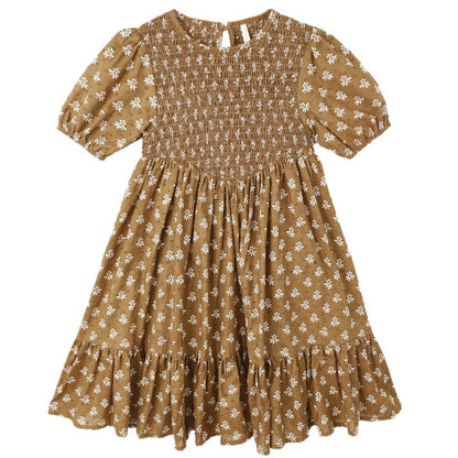 The Girls' Lydia Dress by Rylee & Cru is a brown, short-sleeve dress with a white floral print, shirred bodice, ruffled hem, and gathered skirt—an effortlessly chic smocked style for any occasion.