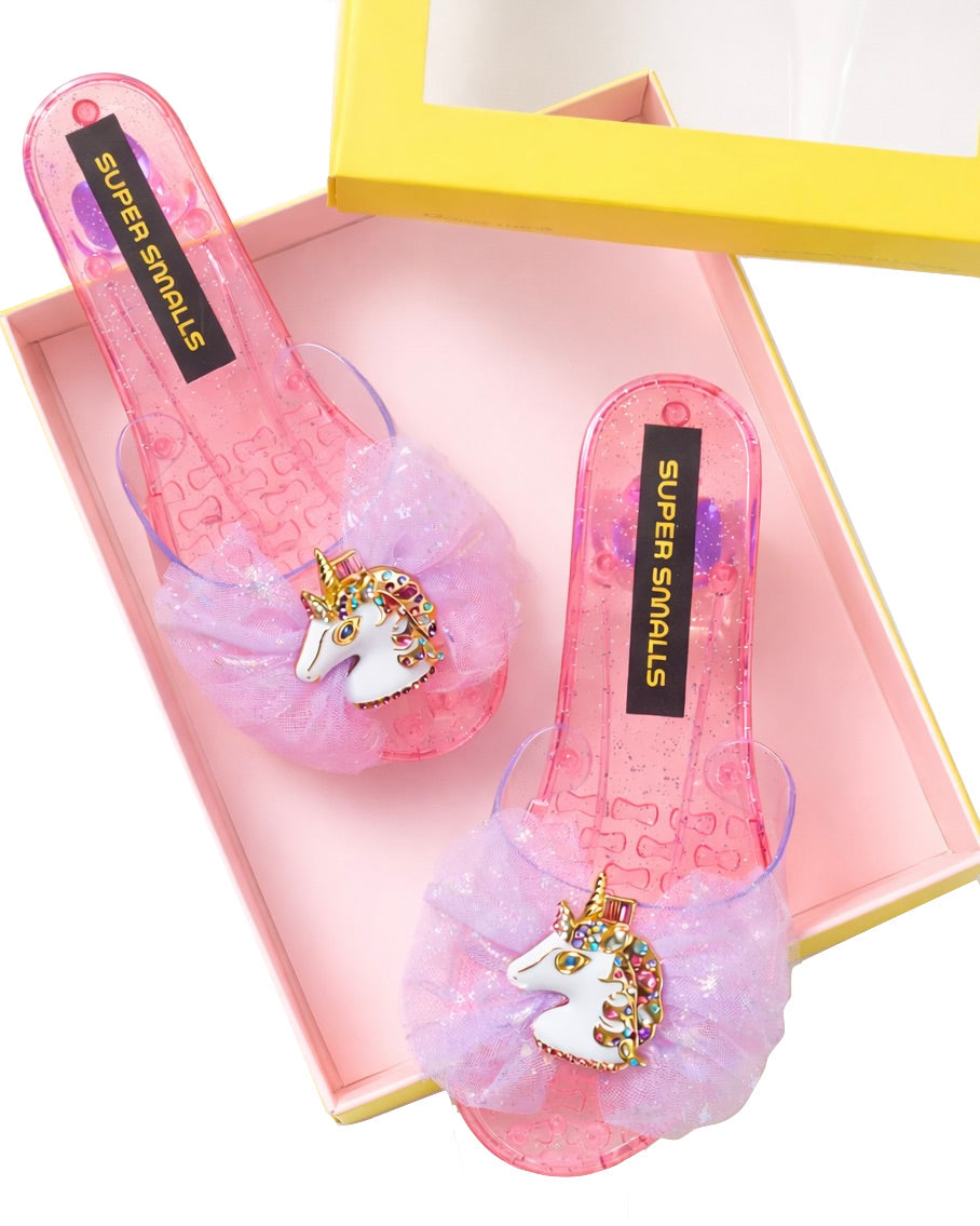 Unicorn Wishes Playshoes by Super Smalls: pink, glittery children's sandals with unicorn decorations—ideal for dress-up or play. Comes in a box with yellow edges.