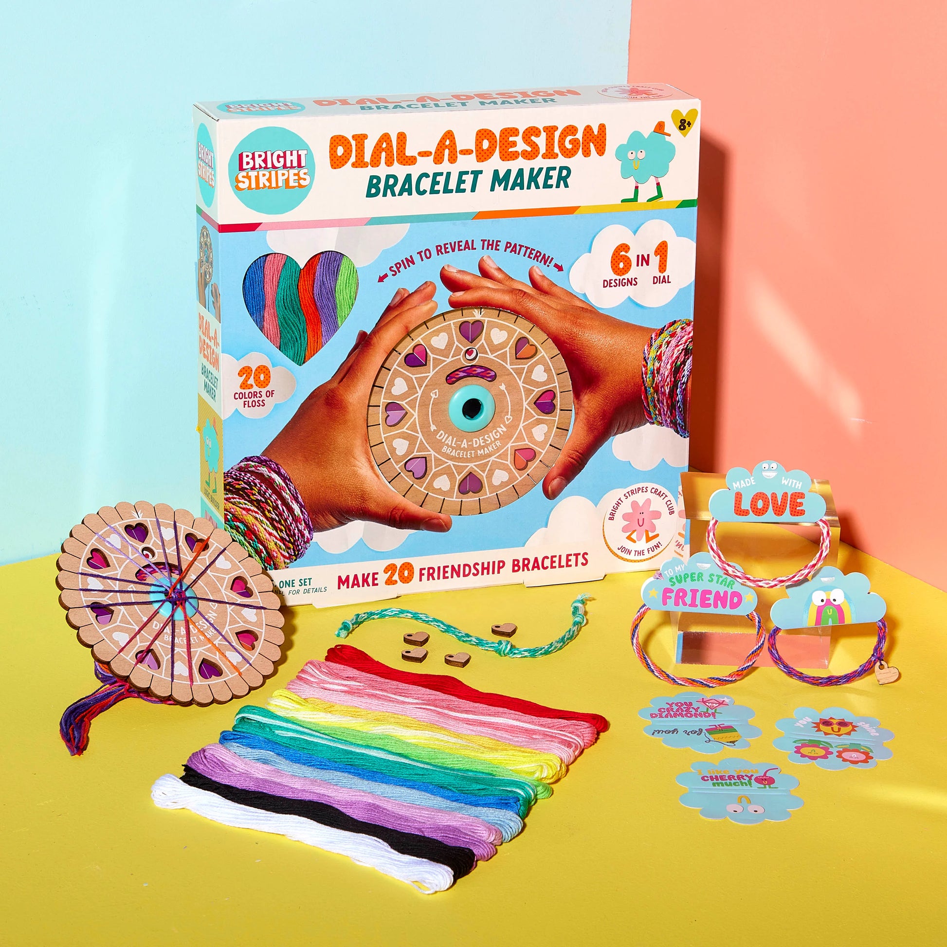 The Bright Stripes Dial-A-Design Bracelet Wheel offers an innovative design with colorful threads, bracelet patterns, and completed bracelets on a vibrant background, ensuring creativity and fun for everyone involved.