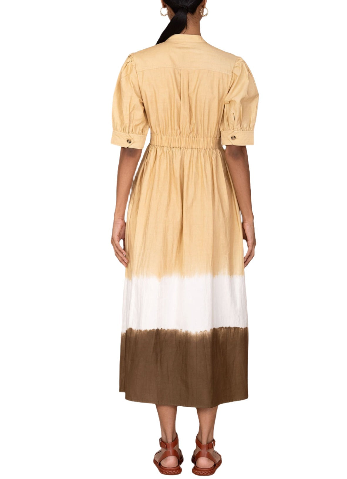 Back view of a person wearing the Banjanan Daffodil Dress, a beige, white, and brown ombre midi dress with short puff sleeves and brown sandals, crafted from luxurious cotton sateen.