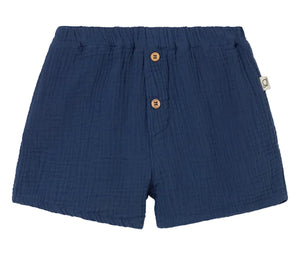 The Cozmo Baby Boys' Dale Shorts feature navy blue textured gauze, an elastic waistband, two wooden front buttons, and a side fabric tag—stylish and comfy toddler shorts.