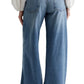 Rear view of a person wearing AG Stella Jeans by AG Jeans in a light indigo wash and a white long-sleeve blouse.