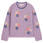 The Girls’ Zuzanna Sweater from Louise Misha is a lilac knit sweater with long sleeves, featuring a crocheted scalloped neckline and detailed with pink, white, and blue handmade floral embroidery, finished with a label at the neckline.