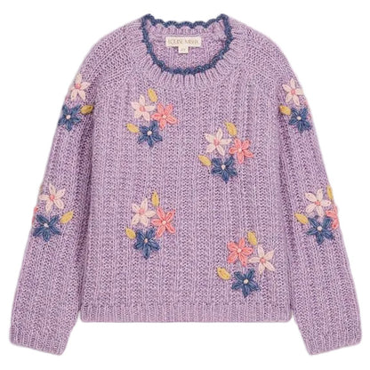 The Girls’ Zuzanna Sweater from Louise Misha is a lilac knit sweater with long sleeves, featuring a crocheted scalloped neckline and detailed with pink, white, and blue handmade floral embroidery, finished with a label at the neckline.