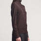 A person wearing the Kallmeyer Leona Silk Wool Cardigan and dark pants, standing sideways against a plain light background.