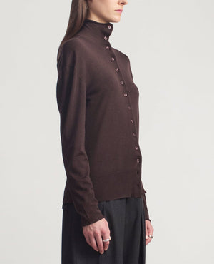 A person wearing the Kallmeyer Leona Silk Wool Cardigan and dark pants, standing sideways against a plain light background.