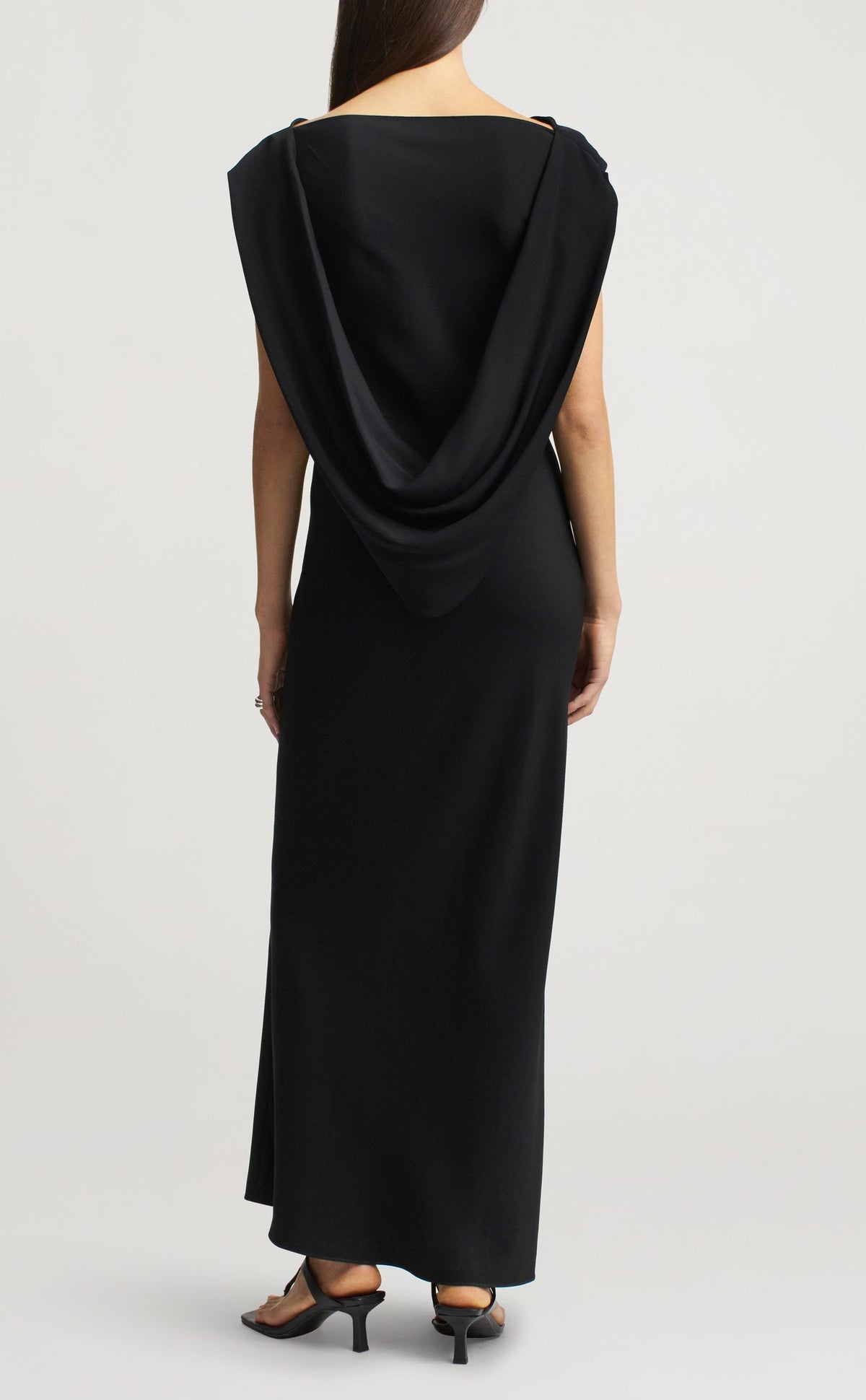 Back view of the Kallmeyer Gilda Bias Dress, a sleeveless black viscose cady floor-length gown with a draped cowl back.