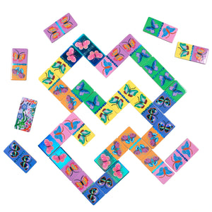Eeboo’s Giant Shiny Butterfly Dominoes form a vibrant winding path on a white surface, capturing the fun of domino games—perfect for family game night—with a few pieces scattered at the edges.