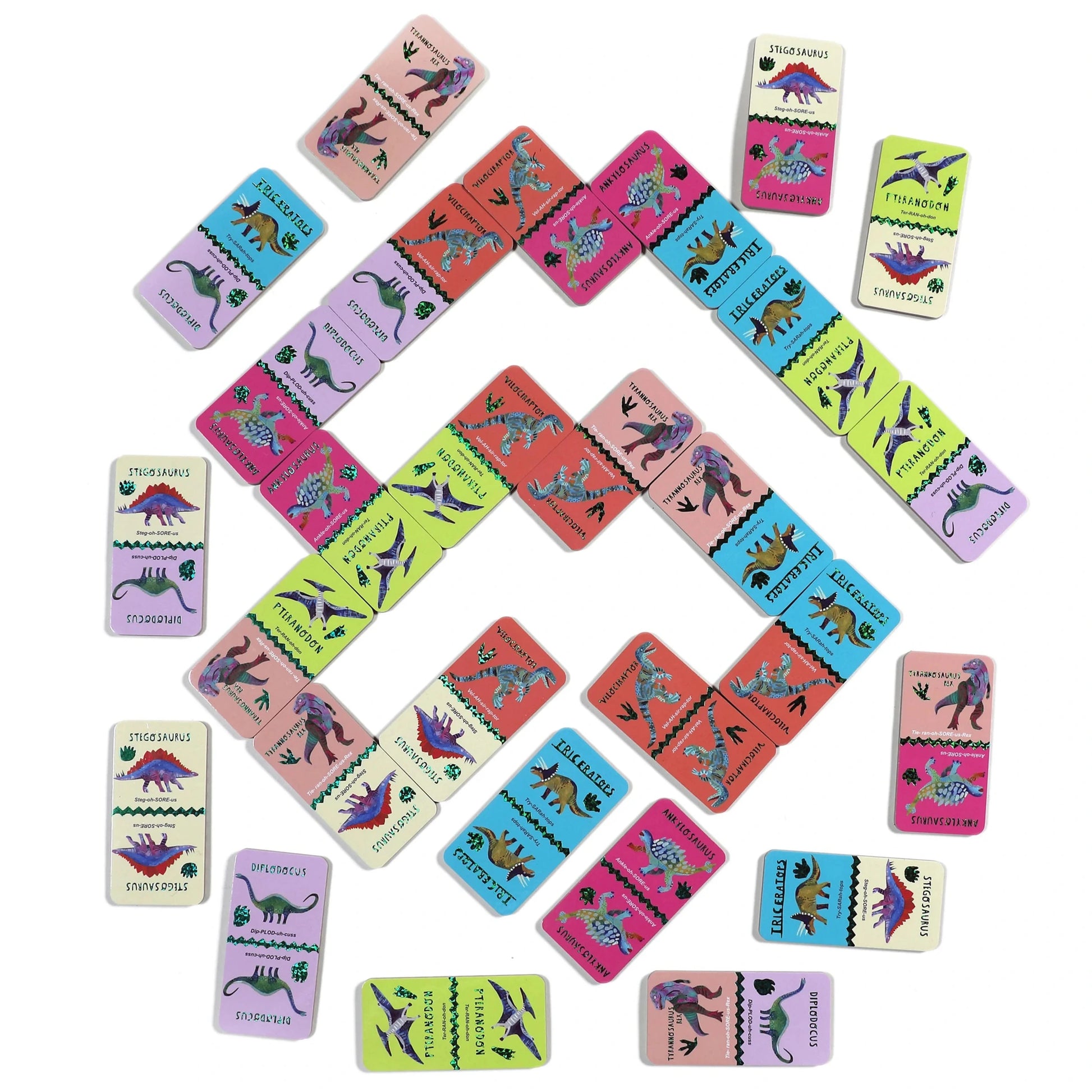 Eeboo’s Giant Shiny Dinosaur Dominos feature eye-catching holographic foil accents and colorful, geometric patterns on a white background, making them a fun and educational toy for kids.