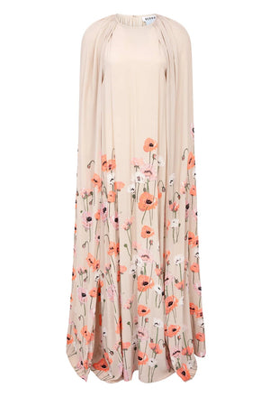 The Minnie Poppies Dress by Bernadette is a long beige cape gown featuring a high neckline, flowing silhouette, and red, pink, and white floral print along the lower half and hem.