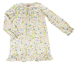 The Girls’ Sunday Morning Dress by Timo & Violet is a long-sleeve, knee-length dress made from soft, GOTS-certified organic cotton, featuring a charming floral and bird print on white fabric with ruffled cuffs and hem.