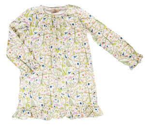 The Girls’ Sunday Morning Dress by Timo & Violet is a long-sleeve, knee-length dress made from soft, GOTS-certified organic cotton, featuring a charming floral and bird print on white fabric with ruffled cuffs and hem.