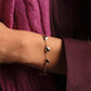Anabel Aram Heart Station Bracelet featuring a gold chain with small, shiny heart-shaped charms with a beaded border worn on a wrist.