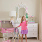 A young girl stands barefoot in a bedroom, tossing tennis balls, wearing The Beaufort Bonnet Company’s Girls' Prepletic™ Hayword Half Zip, with rackets and tennis accessories scattered around her.