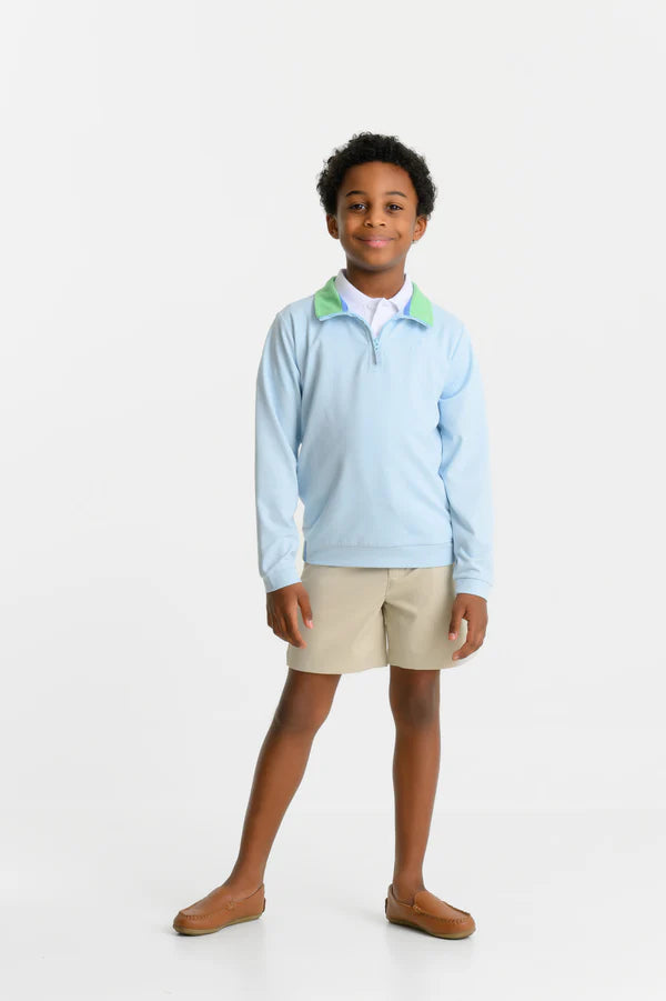 A boy faces the camera wearing The Beaufort Bonnet Company’s Baby Boys’ and Boys’ Prepletic™ Hayword Half Zip with a Grace Bay Green collar, beige shorts, and brown loafers against a white background.