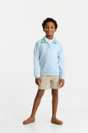 A boy faces the camera wearing The Beaufort Bonnet Company’s Baby Boys’ and Boys’ Prepletic™ Hayword Half Zip with a Grace Bay Green collar, beige shorts, and brown loafers against a white background.