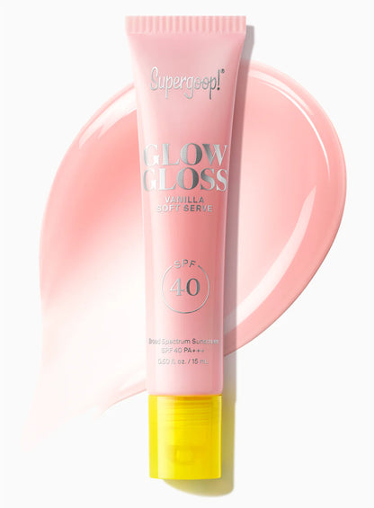 A pink tube of Supergoop Glow Gloss Lip Balm SPF 40 is displayed on a matching pink smear, offering ultra-hydrated lips and a non-sticky finish.