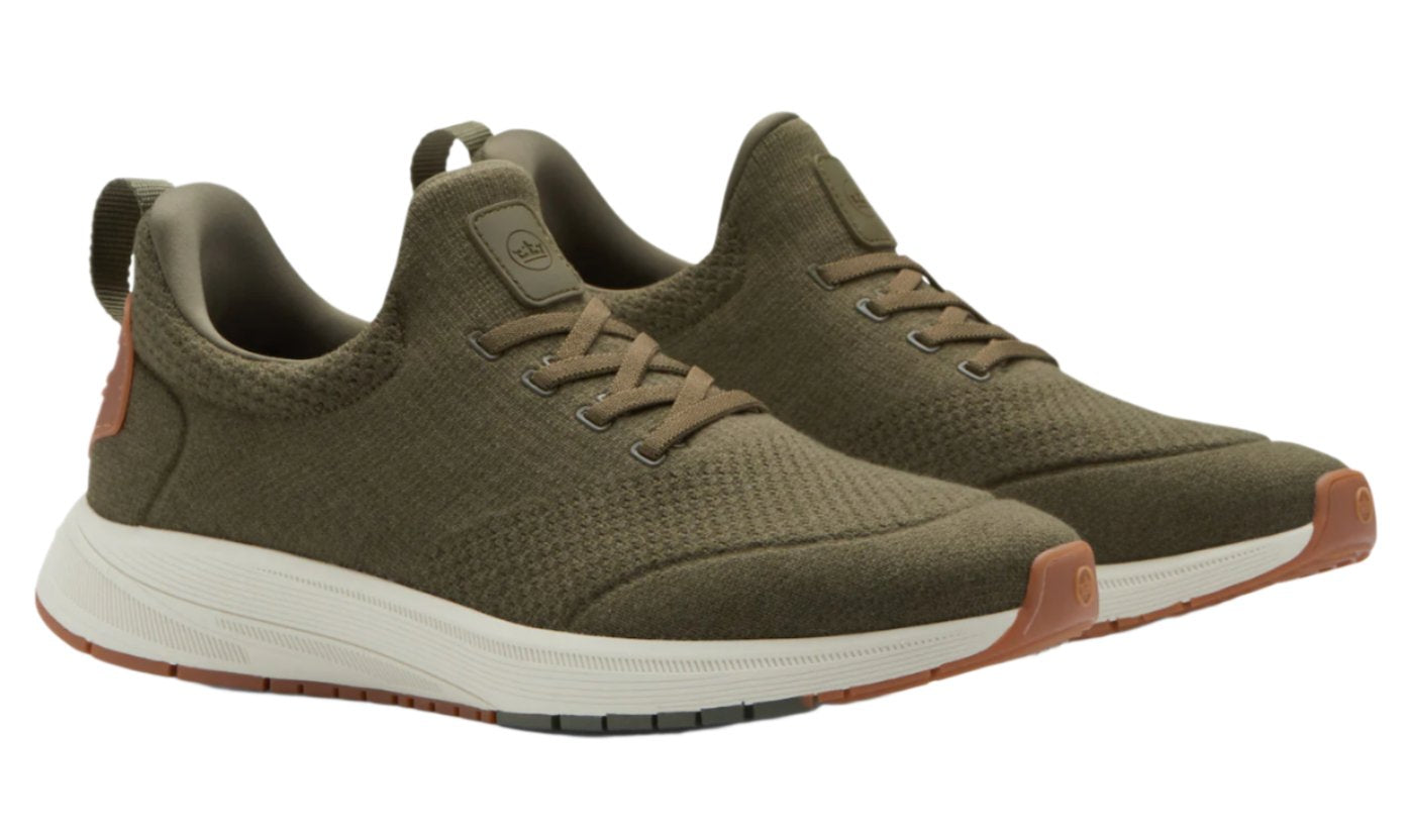 Introducing the Peter Millar Tellustride Sneaker: a stylish pair of olive green knit sneakers, highlighted with white soles and tan accents. Crafted by Peter Millar, these shoes feature a memory foam insole for extra comfort, displayed beautifully from a side angle.