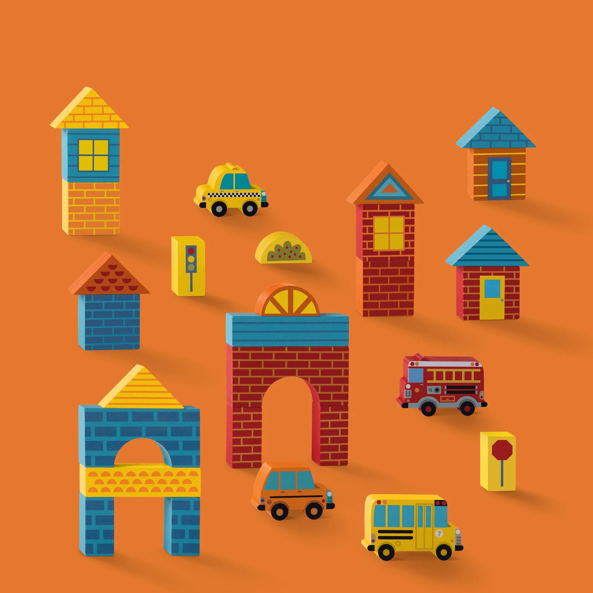 The Build & Play Wood Blocks Busy City set by Crocodile Creek features colorful blocks arranged as buildings and vehicles—like a taxi, school bus, and fire truck—displayed on an orange background.