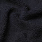 Close-up view of black crinkle fabric with visible ridges and folds, as featured on Hunza G’s Domino Swim one-size swimsuit.