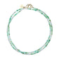 Introducing the Jane Win Double Wrap Beaded Necklace—a versatile double-strand piece adorned with small green and white beads, finished with a gold clasp and a round gold tag engraved with initials. Perfect for layering or wearing solo, this lariat necklace is your new favorite accessory.