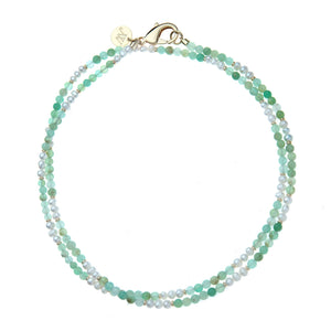 Introducing the Jane Win Double Wrap Beaded Necklace—a versatile double-strand piece adorned with small green and white beads, finished with a gold clasp and a round gold tag engraved with initials. Perfect for layering or wearing solo, this lariat necklace is your new favorite accessory.