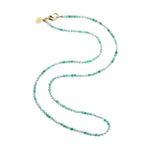 The Jane Win Double Wrap Beaded Necklace is a versatile accessory featuring alternating green and white beads, finished with a gold clasp and a round gold tag, shown against a white background.