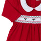 This Kissy Kissy CLB Holiday Medley 24 hand smocked mistletoe dress set for babies features a charming red design made of soft Pima cotton, complete with a white Peter Pan collar, short sleeves, and a beautifully smocked chest adorned with green and red holly embroidery.