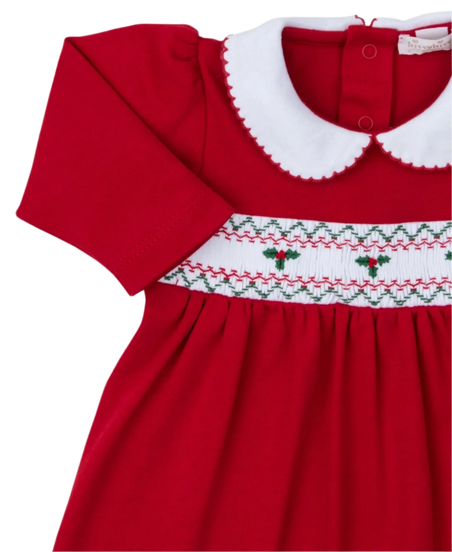 This Kissy Kissy CLB Holiday Medley 24 hand smocked mistletoe dress set for babies features a charming red design made of soft Pima cotton, complete with a white Peter Pan collar, short sleeves, and a beautifully smocked chest adorned with green and red holly embroidery.