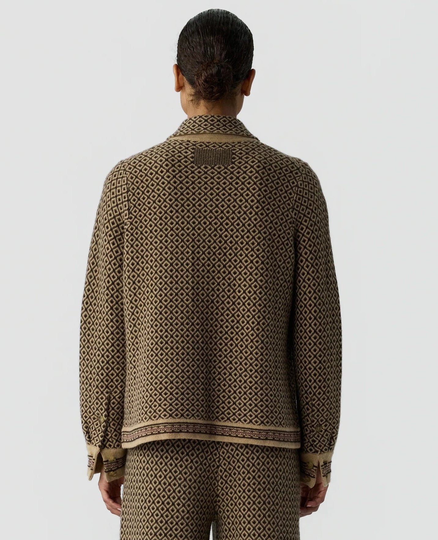 A person is seen from behind wearing a matching brown and beige geometric patterned jacket and relaxed fit pants, paired with the Dylan Marquise Shirt from Guest in Residence, standing against a plain light gray background.