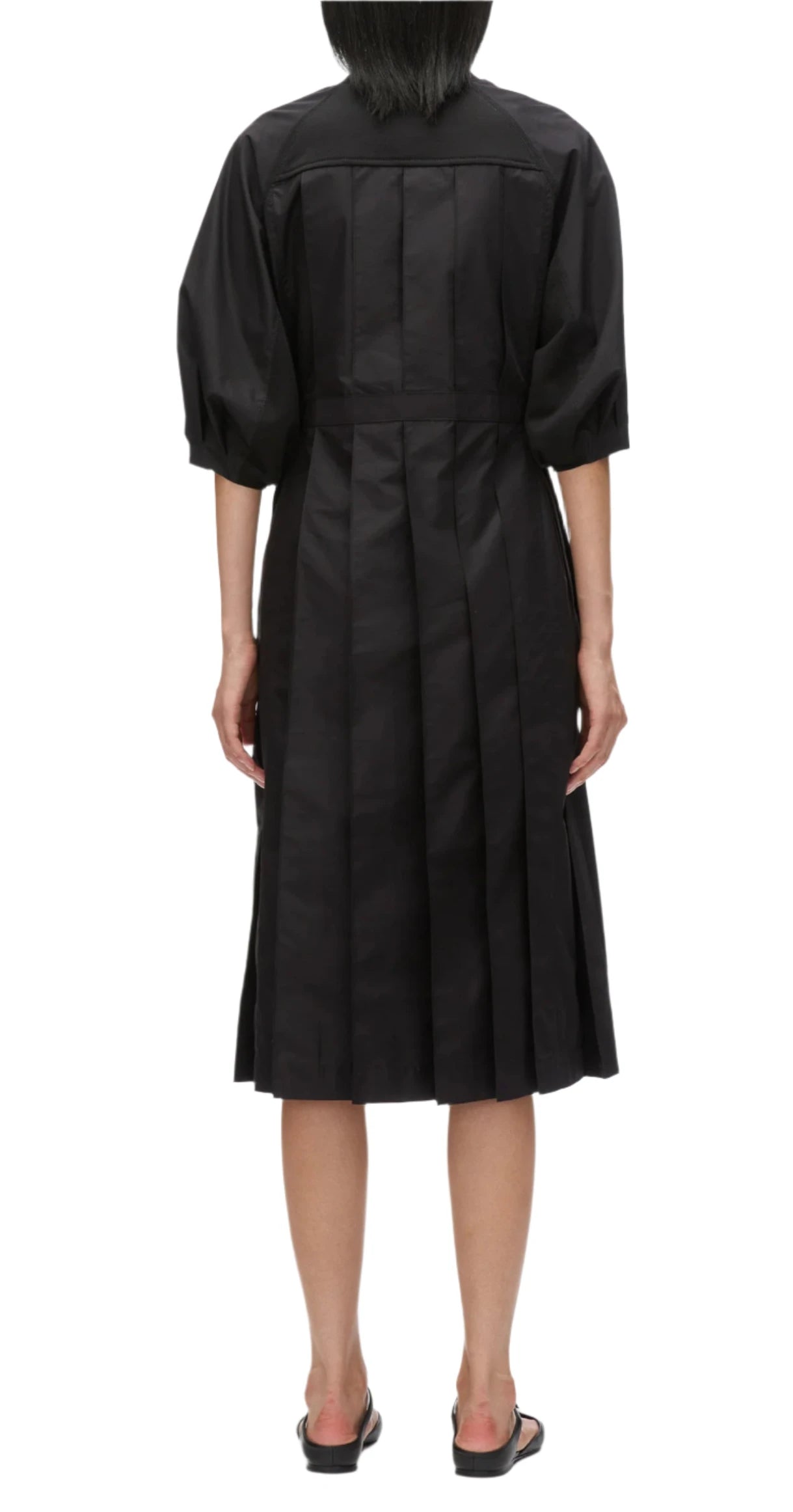 A woman in a black 3.1 Phillip Lim Lantern Sleeve Sweatshirt Dress, adorned with elegant lantern sleeves, viewed from the back.