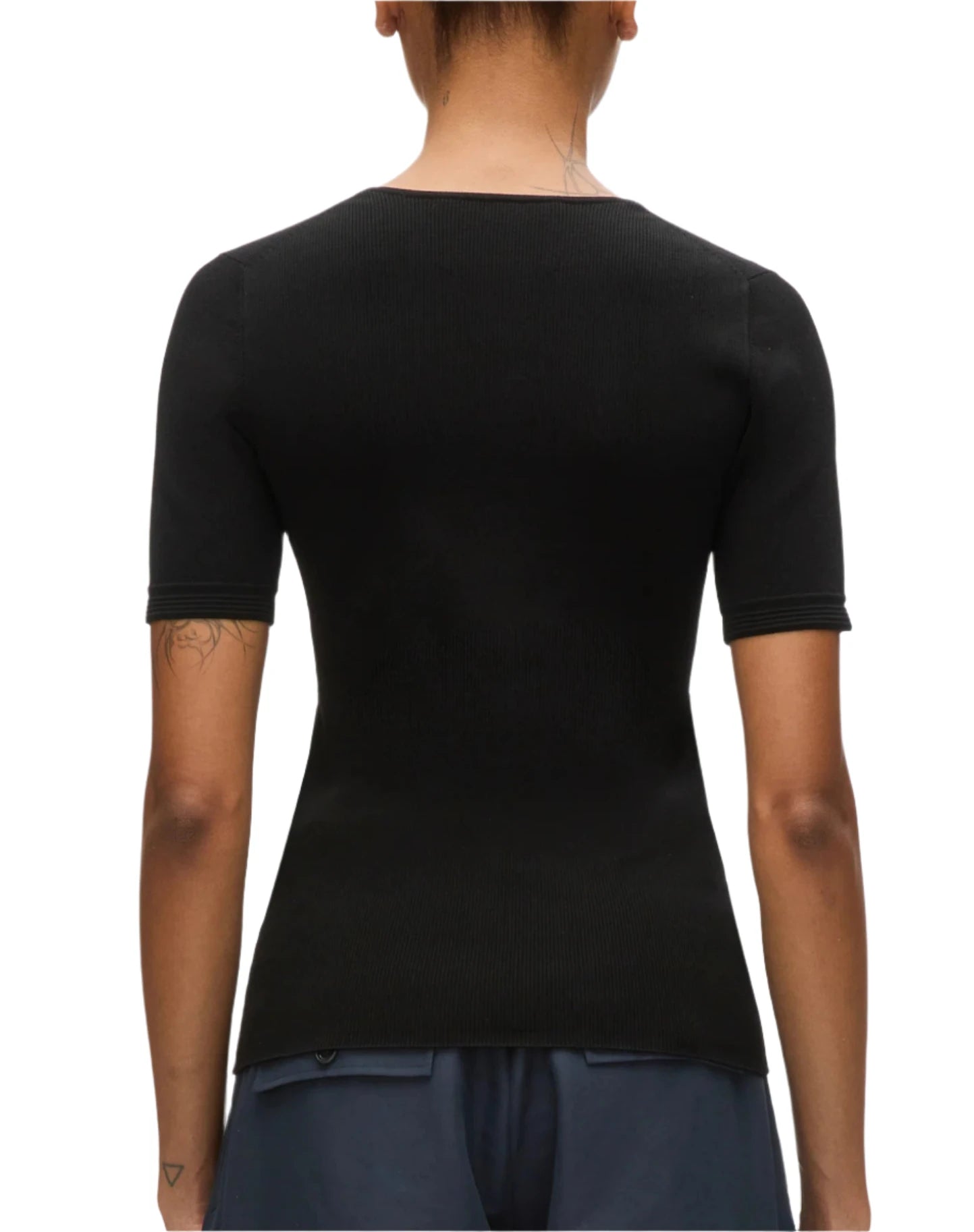 A person is pictured from the back wearing a 3.1 Phillip Lim Compact Rib V-Neck Top in black, featuring a flattering fit, paired with blue pants - an ideal choice for wardrobe foundations.