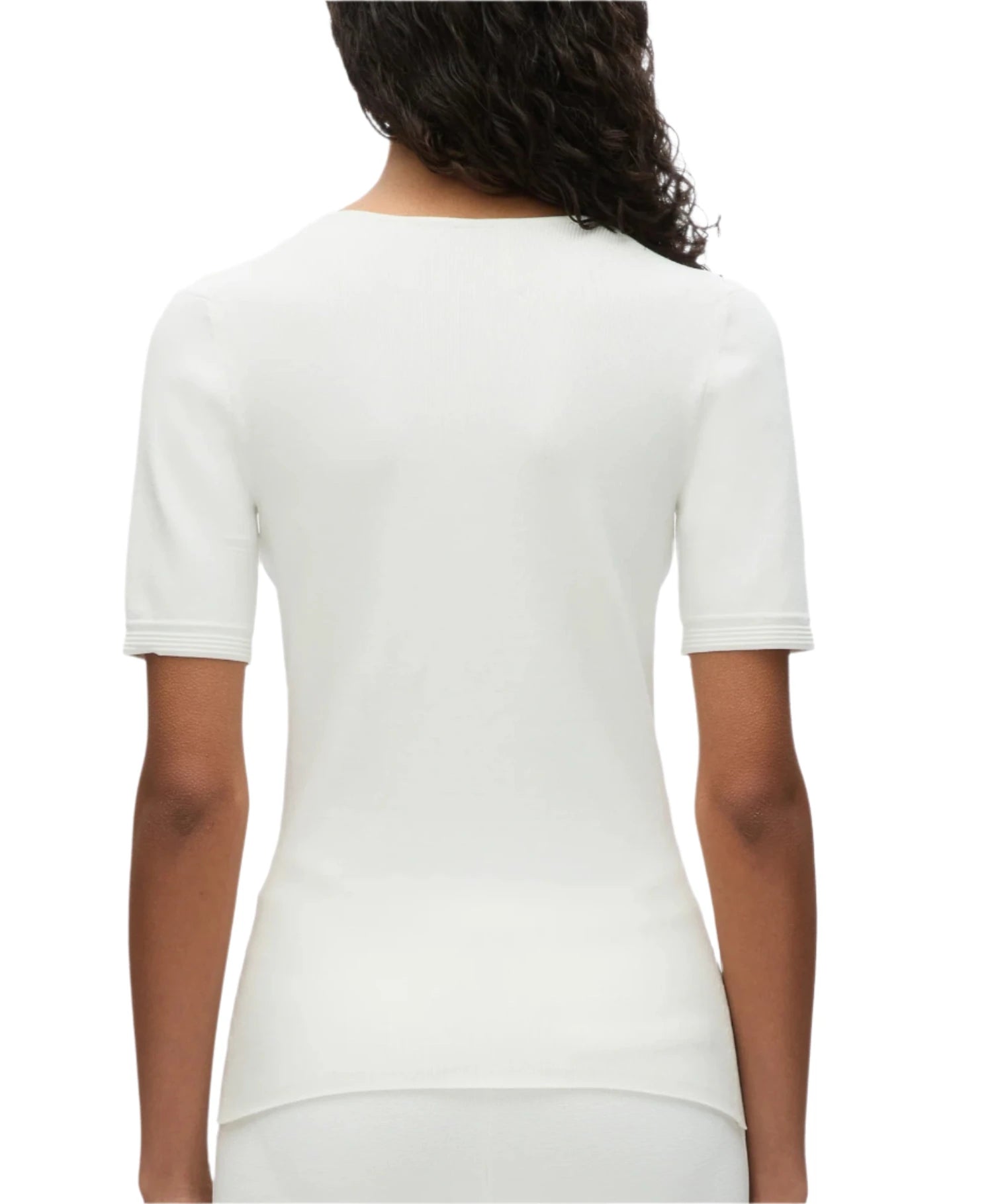 A person with curly hair is wearing the 3.1 Phillip Lim Compact Rib V-Neck Top, a white, short-sleeved top that offers a flattering fit. They are facing away from the camera, highlighting one of their wardrobe foundations.