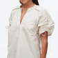 A woman models the 3.1 Phillip Lim Ruched Sleeve V-Neck Top in technical poplin, showcasing short sleeves with drawstring ruching, pictured from shoulders to hips against a plain background.