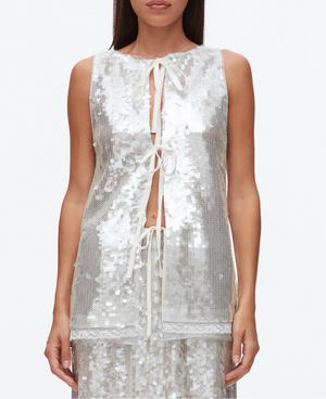 A woman wears the 3.1 Phillip Lim Sequin Flounce Tank with Bows over a matching skirt, featuring silver sequins, front tie bows, and a lace-trimmed organza hem, set against a plain white background.