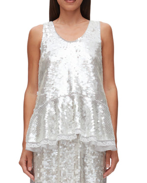 A woman wears the 3.1 Phillip Lim Sequin Flounce Tank with Bows, featuring sparkling sequins and a flounced hem, against a plain background.