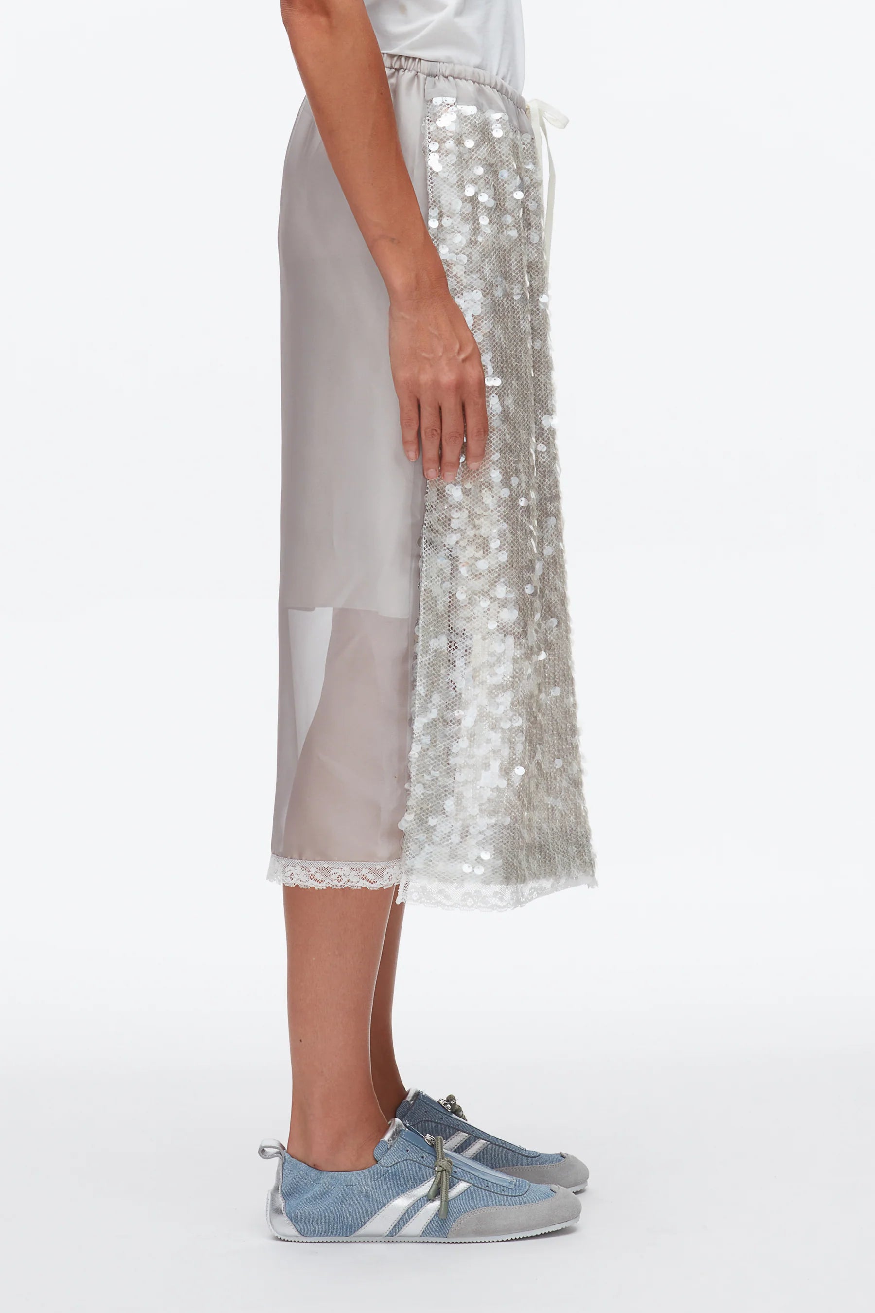 A person in profile wears the 3.1 Phillip Lim Sequin Pull On Skirt with a drawstring waistband and blue sneakers, standing against a plain white background.