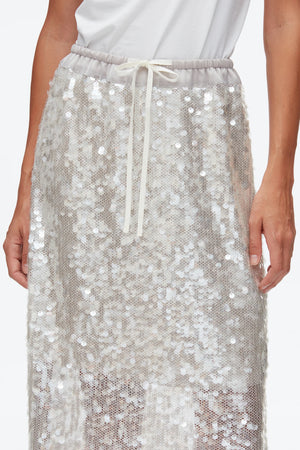 A person wears the 3.1 Phillip Lim Sequin Pull On Skirt, a white sequin midi with a drawstring waistband, paired with a tucked-in white top; only the skirt and torso are visible.