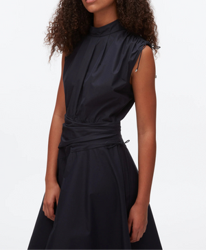 A woman models the 3.1 Phillip Lim Ruched Handkerchief Dress—a sleeveless, high-neck black dress with a fitted waist and subtle gathers—in crisp technical poplin, standing against a plain white background.