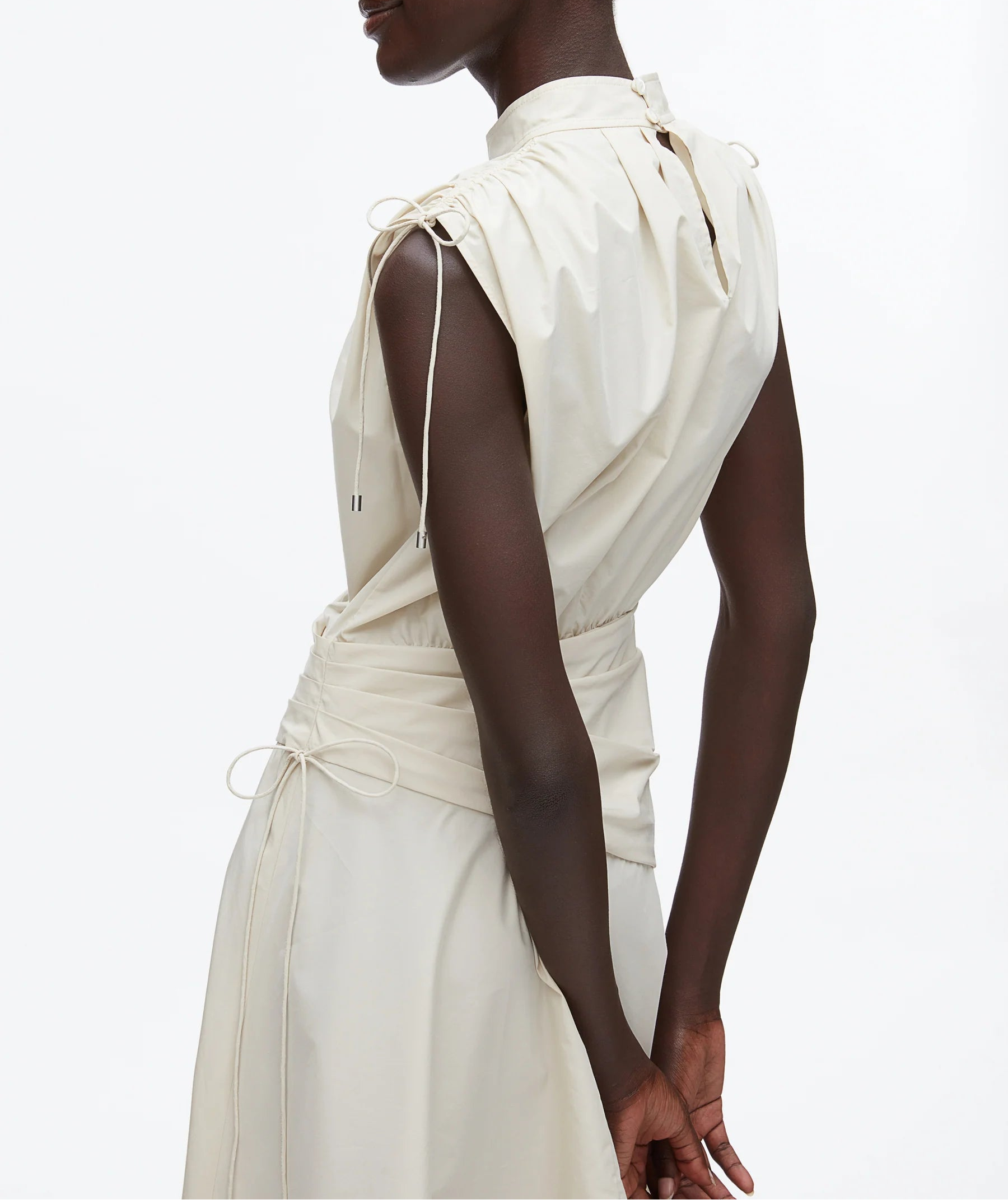 Model wears the 3.1 Phillip Lim Ruched Handkerchief Dress, a sleeveless technical poplin style with drawstring shoulders and waist, photographed from the back against a plain white background.