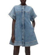 A person wearing the 3.1 Phillip Lim Trapeze Light Denim Dress, a short-sleeve design with visible seams, a chic trapeze silhouette, and a front zipper closure.