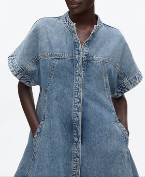 A model wears the 3.1 Phillip Lim Trapeze Light Denim Dress, a short-sleeve style with front seams, side pockets, and a trapeze silhouette, shown from shoulders to above the knees.