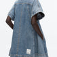 A person wears the 3.1 Phillip Lim Trapeze Light Denim Dress, featuring a relaxed trapeze silhouette, short sleeves, side pockets, and a visible white label near the hem.